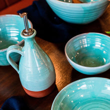 Load image into Gallery viewer, Turquoise oil pourer and 4 bowls sitting on a dark wooden table
