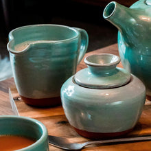 Load image into Gallery viewer, Turquoise milk jug and sugar bowl, teapot in the corner, teaspoon at the front on a wooden table.

