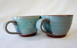 2 turquoise espresso cups side by side on a white background