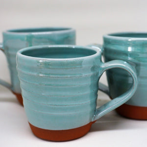 3 turquoise mugs on a white background