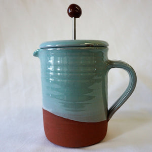 turquoise ceramics cafetiere pot on a white background